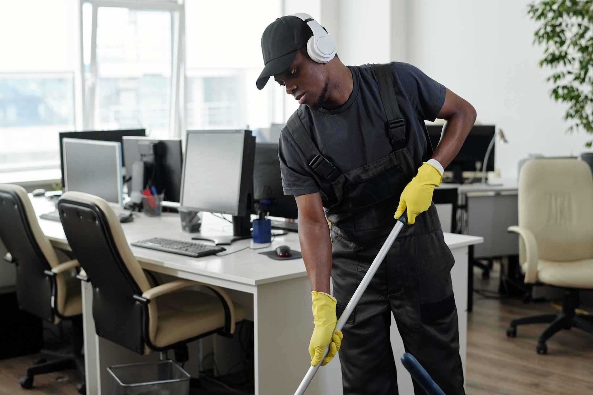 A man in an office cleaning the floor