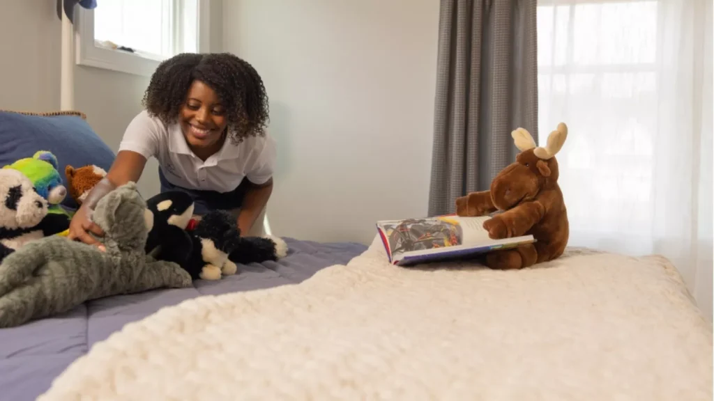 A woman is reading to her stuffed animals.