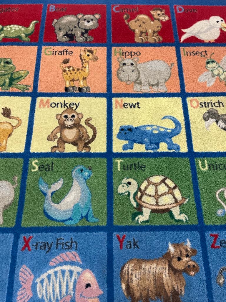 A colorful rug with different animals and letters.