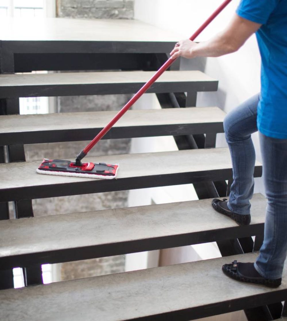 A person with a mop on some steps