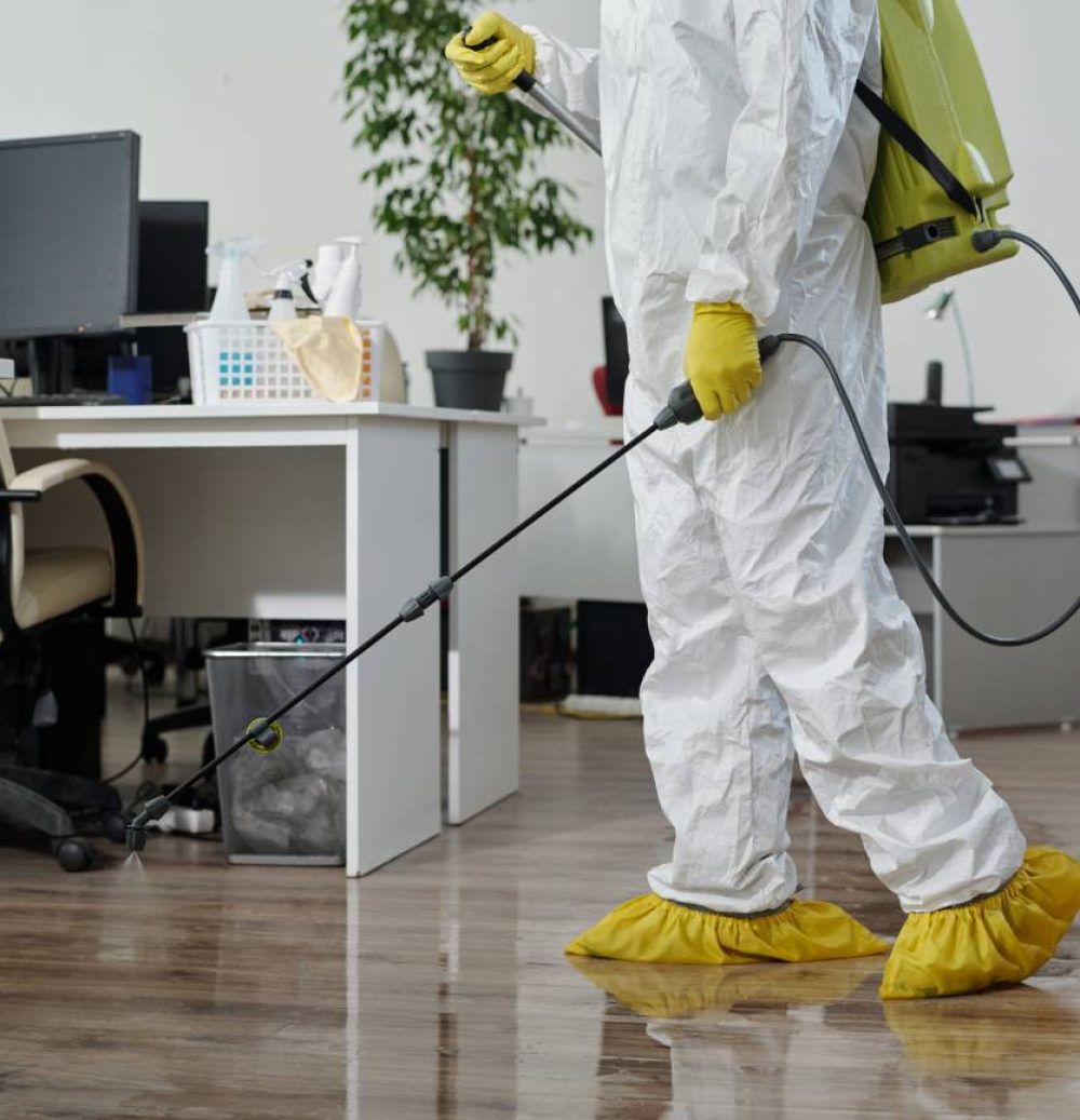 A person in white suit holding a mop